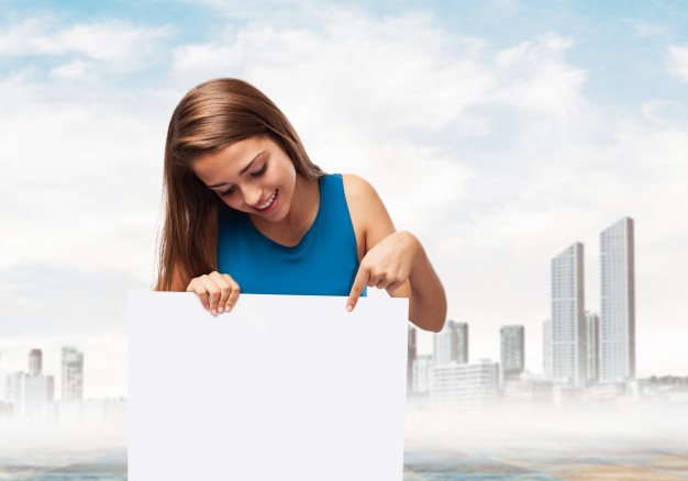 free-woman-holding-a-poster-with-a-town-background-mockup